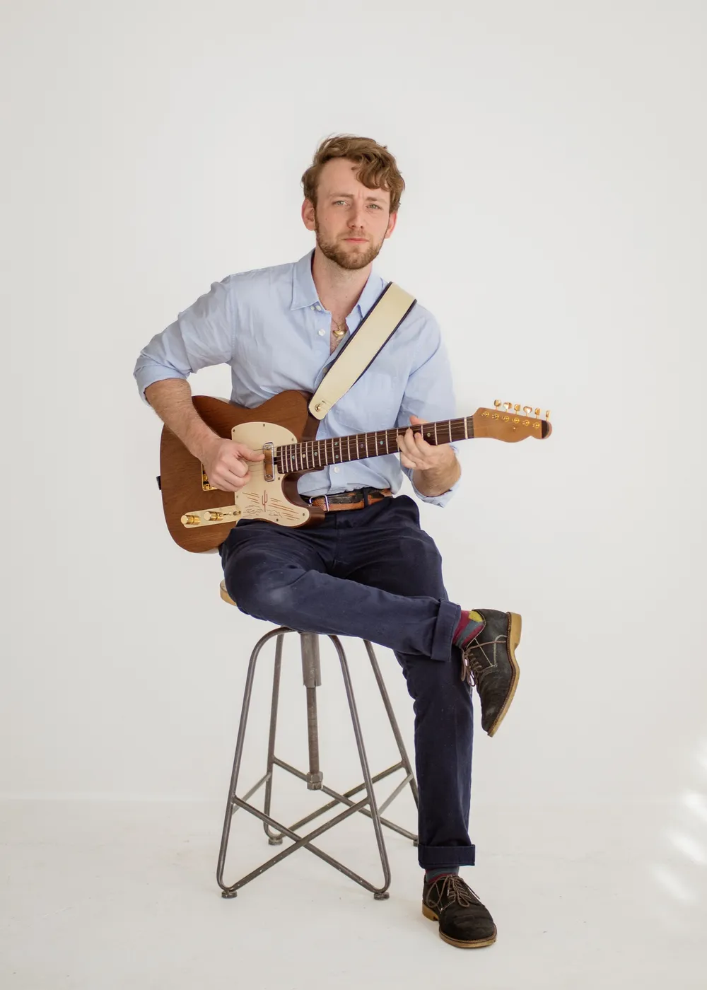 Jordan Lovinger seated with his guitar
