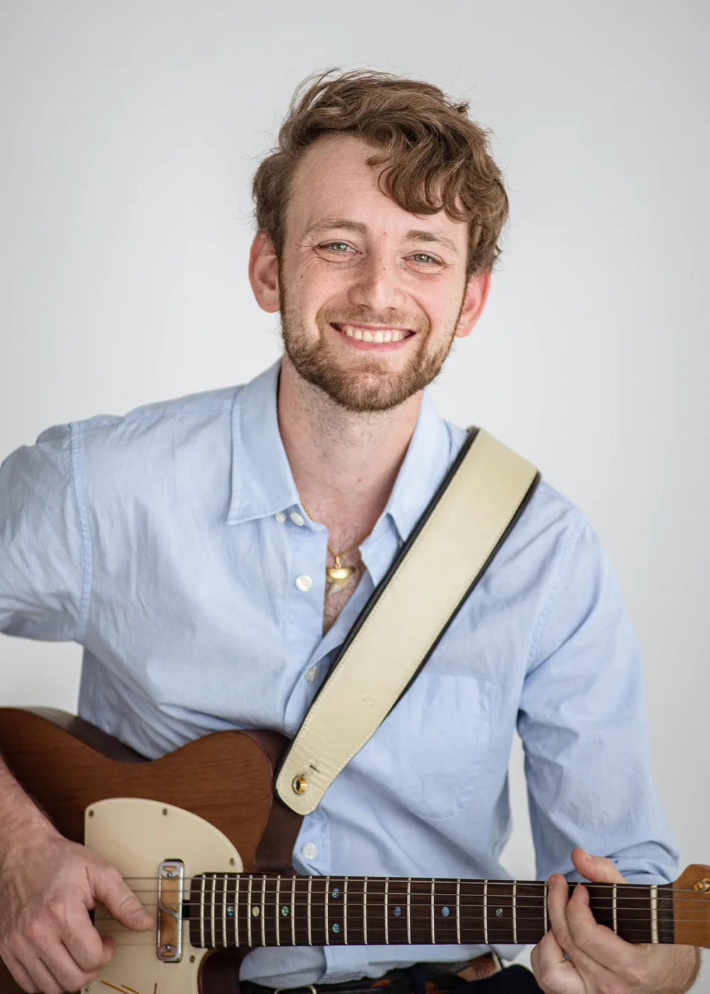 Jordan Lovinger smiling with his guitar